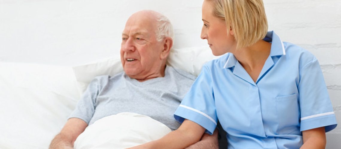 Caring healthcare worker consoling elderly patient